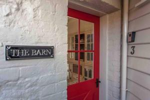 a red door of a building with a red door istg istg at Warm, Inviting & Luxurious The Barn in Sandy Bay