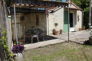 un patio con un tavolo e una sedia in un cortile sul retro di Lou Pitchoun Cabanoun à Eygalières "2-3 Personnes" a Eygalières