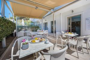 a patio with tables and chairs with food on it at Erato Hotel in Agia Marina Aegina
