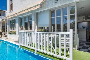 a house with a swimming pool and a white fence at Erato Hotel in Agia Marina Aegina