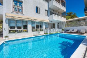 a swimming pool in front of a building at Erato Hotel in Agia Marina Aegina