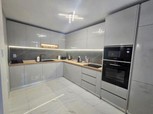 a kitchen with white cabinets and a black appliance at Apartment Bohemi with free parking in Burgas