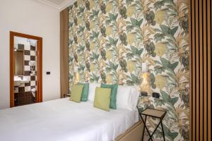 a bedroom with a bed with a floral wallpaper at Hotel Ciao in Rome