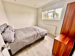 a bedroom with a bed and a window at 5 bed property in SE12 in London