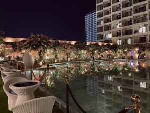 a row of chairs and trees in front of a building at Cozy GoldCoast Apartment in Nha Trang