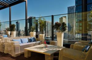 einen Balkon mit Stühlen, einem Tisch und Fenstern in der Unterkunft NYX Hotel Warsaw by Leonardo Hotels in Warschau