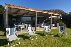 a group of lawn chairs sitting in the grass at The Plett Shed in Plettenberg Bay