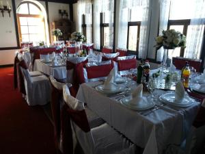 a dining room with white tables and red chairs at Hotel St. Naum in Ljubaništa