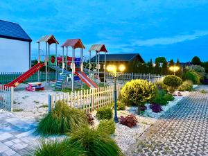 a park with a playground with a slide at Domki Venus z basenem in Ustronie Morskie