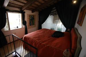 a bedroom with a red bed and a window at Casa Letizia in Brtonigla