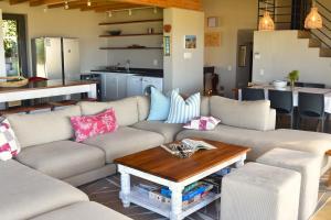 a living room with a couch and a table at The Plett Shed in Plettenberg Bay