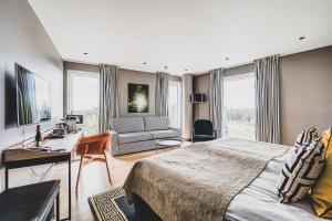 a bedroom with a bed and a desk and a couch at Clarion Hotel Aviapolis in Vantaa