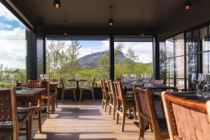 キルピスヤルヴィにあるCahkal Hotelの山の景色を望むテーブルと椅子付きのレストラン