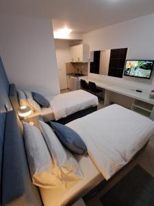 a room with two beds and a desk with a tv at Lucky Studios in Herceg-Novi