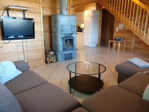 a living room with a couch and a wood stove at Loghouse in Hjorto in Ödkarby