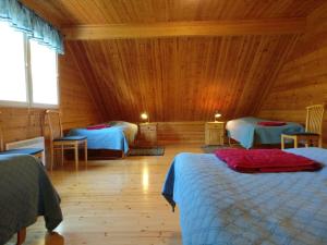 a bedroom with two beds in a wooden cabin at Loghouse in Hjorto in Ödkarby