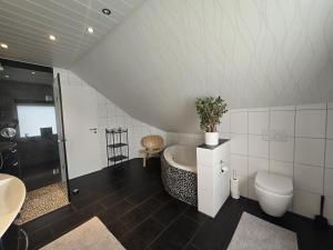 a bathroom with a bath tub and a toilet at Großzügige Ferienwohnung in Weilburg +17 photos