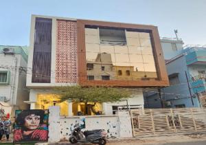 a building with a mirrored facade with a motorcycle parked in front at Triveni International in Varanasi
