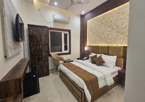 a bedroom with a large bed and a television at Triveni International in Varanasi