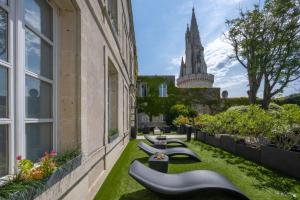 a row of benches on the side of a building at Hôtel La Monnaie Arty & Spa in La Rochelle