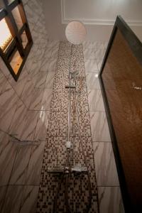 a shower in a bathroom with a tile floor at Appart chic à louer in Lomé