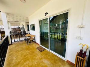 a room with a balcony with a table and chairs at Punam Rukthai Resort in Ban Thung Kha Han