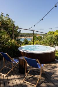 two chairs and a hot tub on a patio at MUTE Hostel Milfontes in Vila Nova de Milfontes