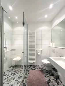 a bathroom with a toilet and a sink and a shower at Apartments am Wall in Bremen +48 photos