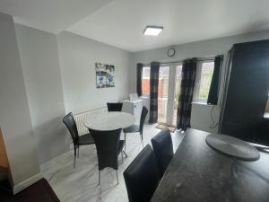 een woonkamer met een tafel en stoelen bij Heathrow Ground Floor Apartment with Garden & Parking in Hayes