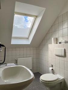 a bathroom with a tub and a toilet and a window at Haus Fliederbusch in Borken