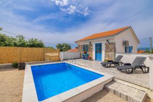 a swimming pool in front of a house at Holiday house KUNTENTA with pool and jacuzzi in Skrbčići