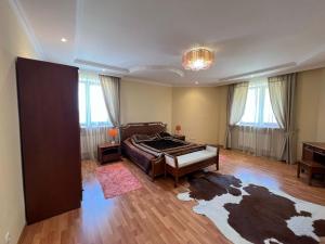 a bedroom with a large bed in a room at Kolsay Tanbalytas Villa in Kolʼbastau