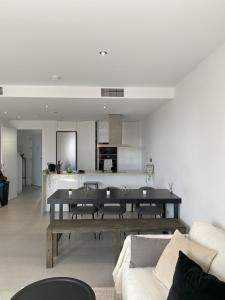 a living room with a table and a kitchen at Elegancia y confort en Casa Moncerrat in Vilanova i la Geltrú