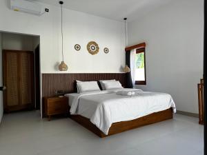 een slaapkamer met een groot bed en een raam bij Villa Calma in Kuta Lombok +21 foto's