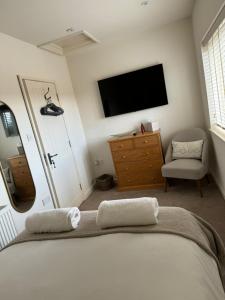a bedroom with a bed and a tv and a chair at Chew View Luxury Apartment in Keynsham