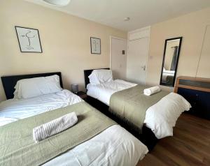 ein Hotelzimmer mit zwei Betten und einem Spiegel in der Unterkunft Central 4 Bedroom House With Driveway in Newcastle upon Tyne + 3 Fotos
