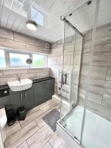 ein Badezimmer mit Waschbecken und Dusche in der Unterkunft Central 4 Bedroom House With Driveway in Newcastle upon Tyne