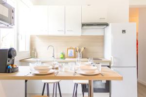 una cucina con tavolo e bicchieri da vino di ZenBNB - Kanji - Proche Tram - Parking Privé - ad Ambilly Altre 9 foto