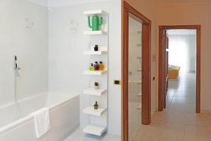 a bathroom with a tub and a shower with white shelves at il Giardino in Civitanova Marche +36 photos