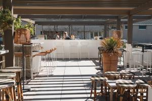 un patio con mesas y sillas y un bar en Hôtel de La Plage, en Biarritz