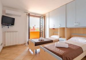 a hotel room with two beds and a tv at Big Garden [Free Wi-fi e Netflix] in Fiumicino