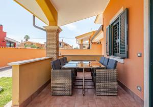 a patio with a table and chairs on a house at Big Garden [Free Wi-fi e Netflix] in Fiumicino