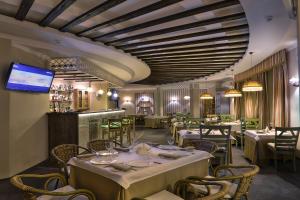 a dining room with tables and chairs and a television at Hotel Complex Sosnoviy Bor in Ivanovo