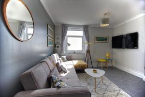 a living room with a couch and a mirror at The Seagulls Nest - Hastings in Hastings