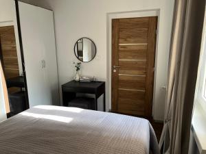 a bedroom with a bed and a mirror and a door at Apartman AURELIA Vinkovci in Vinkovci