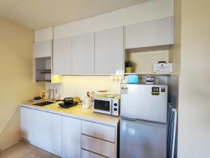 une cuisine avec un réfrigérateur et un micro-ondes dans l'établissement SG Resort Residences Kuantan, à Kuantan 56 autres photos