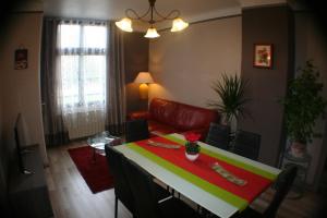 a living room with a table and a couch at Appartement Les Berges de l'Ornain in Bar-le-Duc