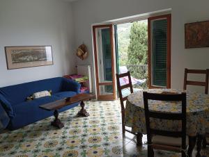 un salon avec un canapé bleu et une table dans l'établissement Galia's beach house, à Zoagli