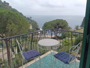 un balcon avec une table et des chaises et l'océan dans l'établissement Galia's beach house, à Zoagli