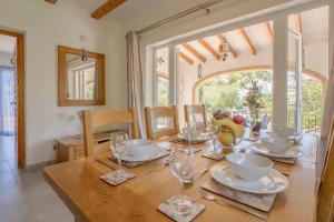 a dining room with a wooden table with wine glasses at Casa Angilaga in Jávea